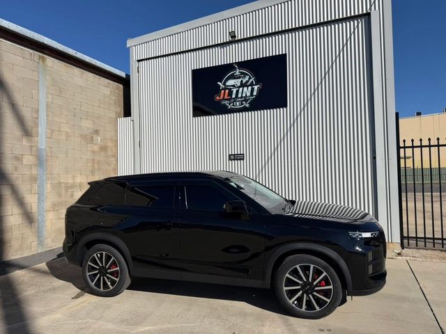 Gloss black SUV with premium window tint, parked outside the JL Tint shop