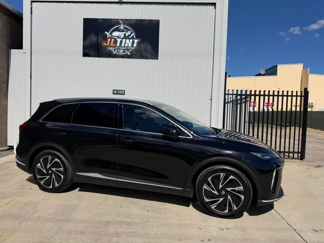 Black SUV with premium window tint, parked outside the JL Tint shop